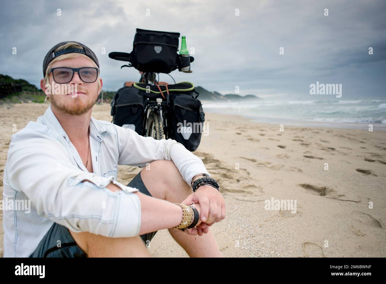 Ciclista a lunga distanza sulla bicicletta da spiaggia dietro di lui Foto Stock