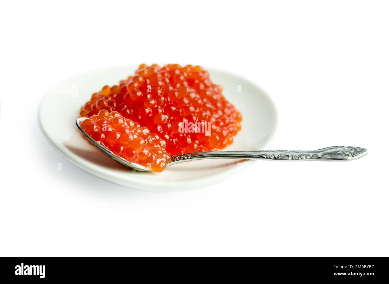 Caviale rosso in un cucchiaio, fondo bianco isolato, primo piano Foto Stock
