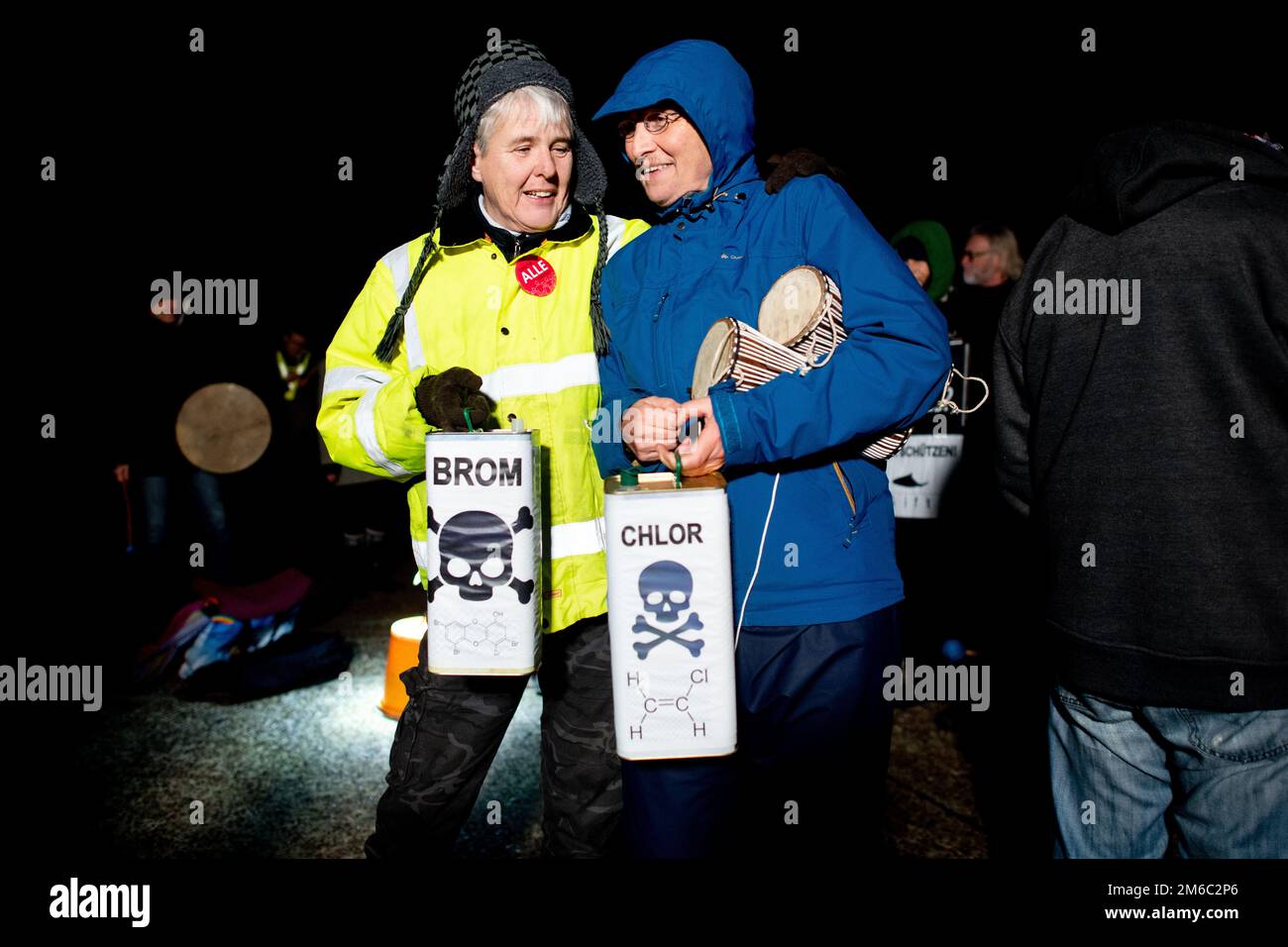 Hooksiel, Germania. 03rd Jan, 2023. Gli ambientalisti detengono simbolicamente due contenitori con le etichette 'bromo' e 'cloro' di fronte al terminale GNL nel Mare del Nord, nel porto esterno di Hooksiel. Criticano lo scarico di cloro e bromo in mare e temono danni al mare di Wadden causati dalle operazioni terminali. Una petroliera con un carico pieno di gas naturale liquefatto è arrivata al terminal GNL di Wilhelmshaven questa mattina per la prima volta da quando è stata aperta. Credit: Hauke-Christian Dittrich/dpa/Alamy Live News Foto Stock