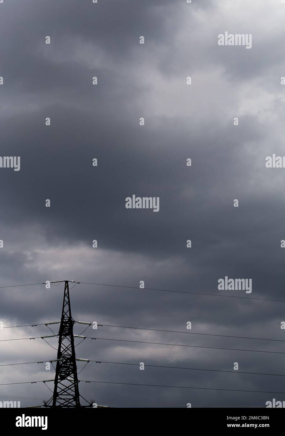 Trasmissione di potenza pilone contro un cielo nuvoloso Foto Stock