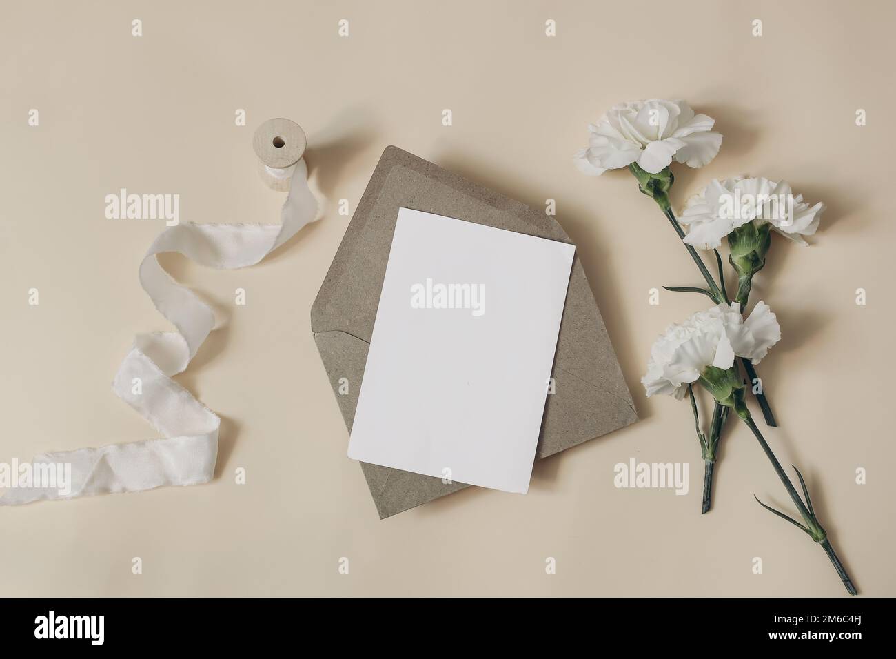 Matrimonio naturale, cancelleria di compleanno ancora vita biglietto di auguri vuoto, invito mockup, busta artigianale. Fiori di garofano bianco, rami di eucalipto Foto Stock