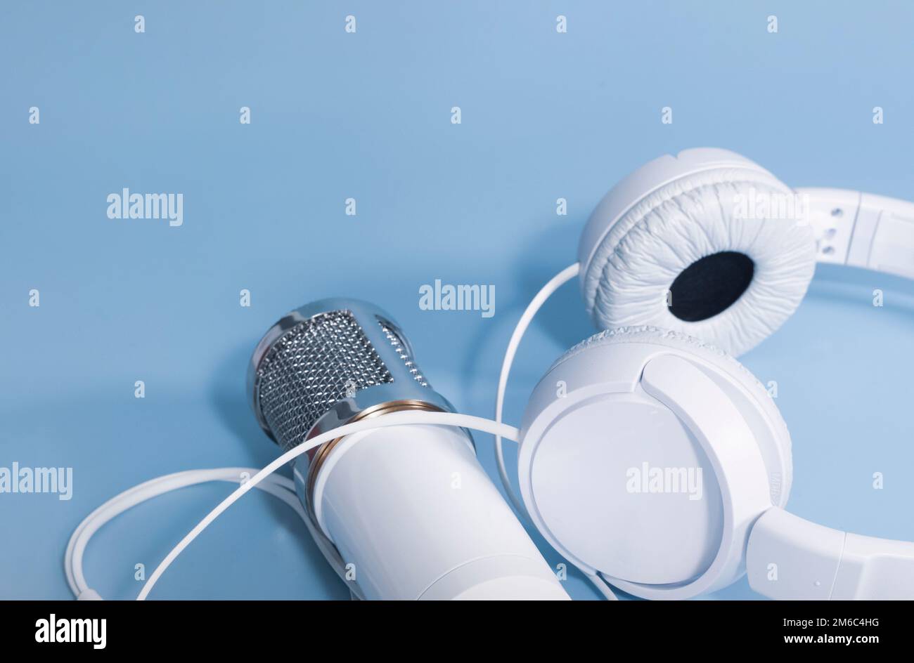 Cuffie e microfono per la registrazione audio su sfondo blu con spazio per il testo Foto Stock