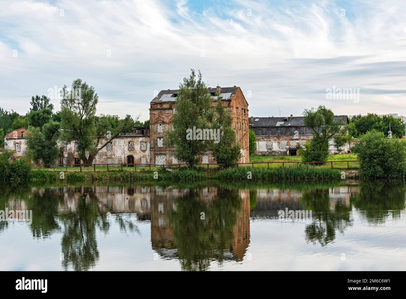 Il vecchio edificio abbandonato in mattoni si riflette nell'acqua Foto Stock