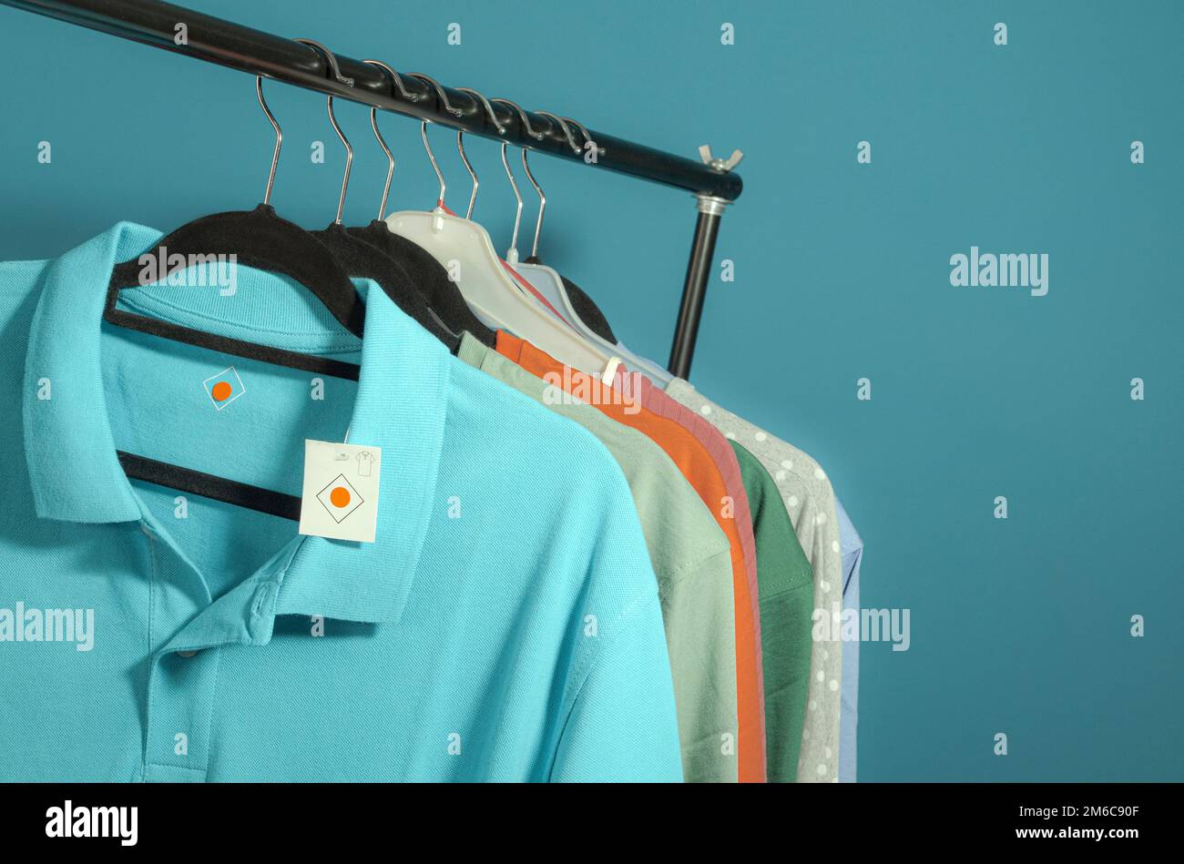 Mettere i vestiti su un appendiabiti di vendita in un negozio Foto Stock