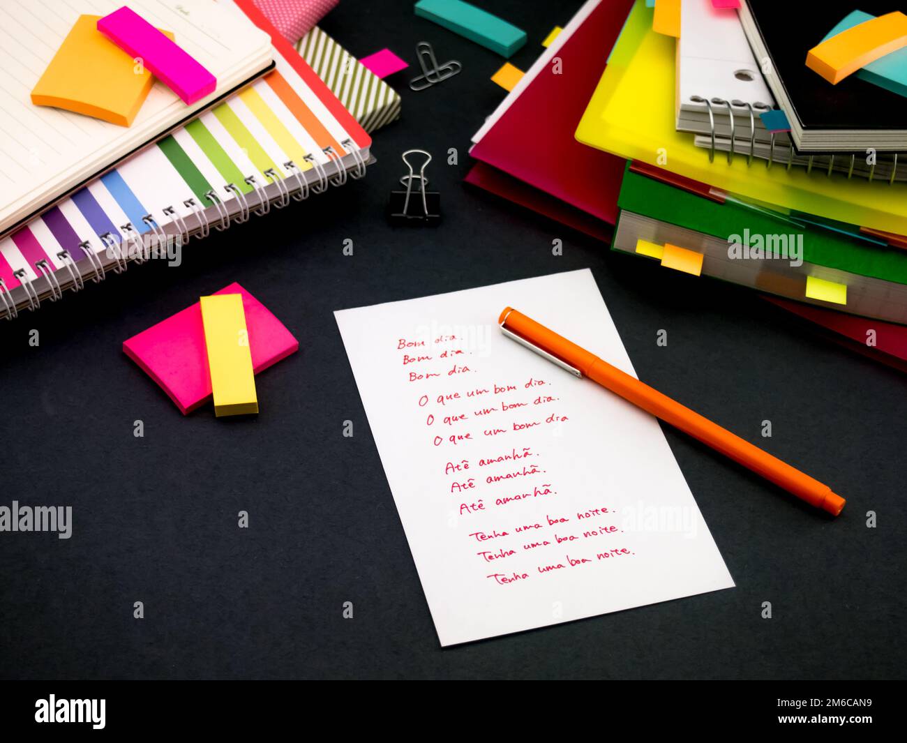 Imparare una nuova lingua scrivere parole molte volte sul notebook; Portoghese (traduzione; buon Mornin Foto Stock