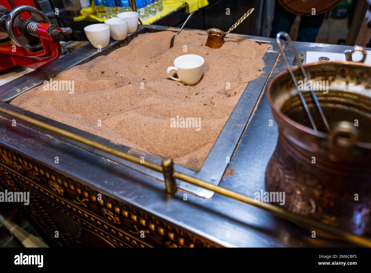 Caffè turco cotto nella sabbia, preparazione del caffè turco da parte del venditore di strada Foto Stock