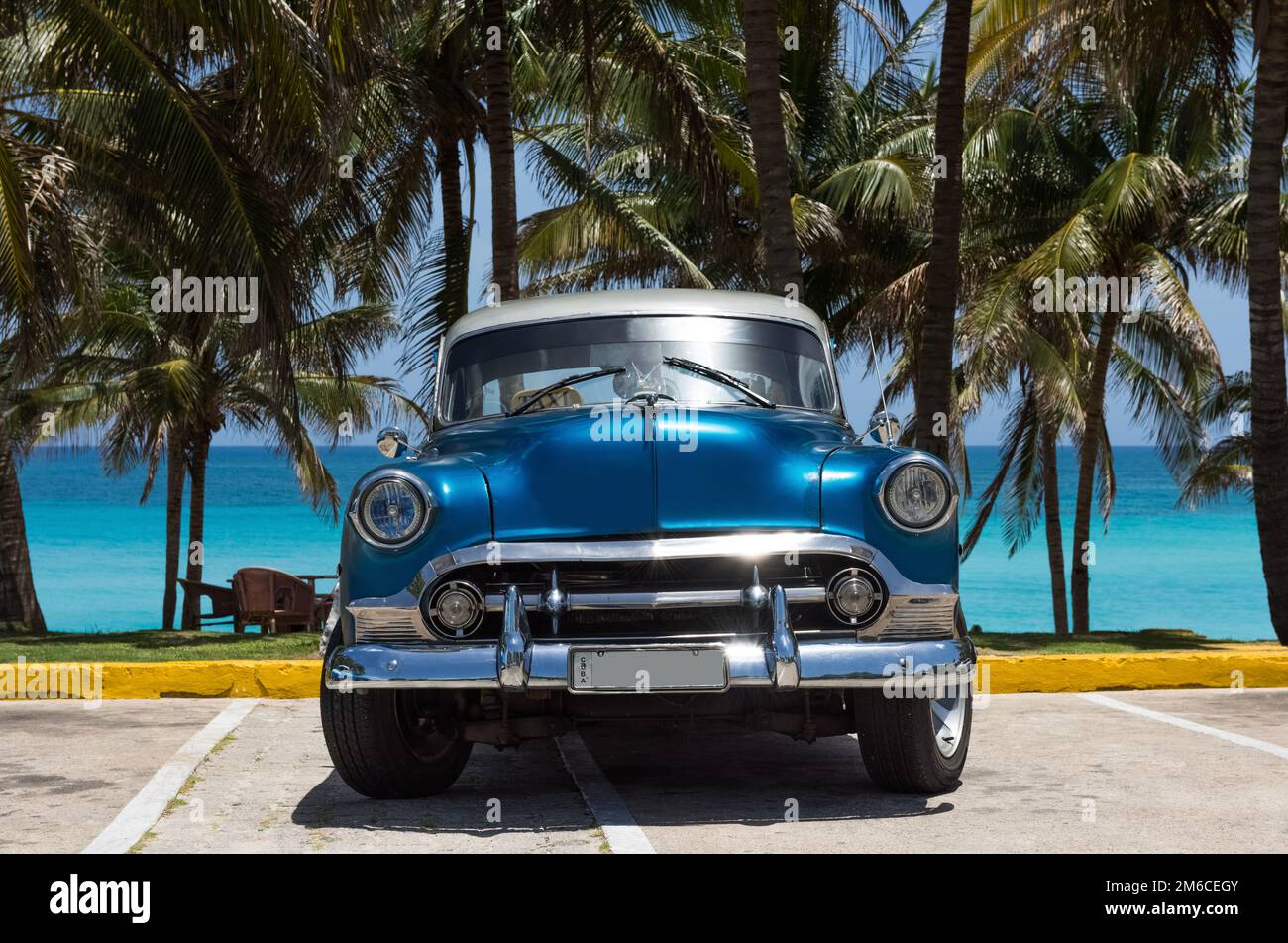 Auto classica blu americano con tetto bianco parcheggiato sotto le palme a Varadero Cuba - Serie Cuba Foto Stock