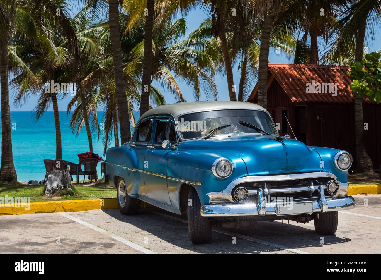 American blu Chevrolet auto classica parcheggiata vicino alla spiaggia sotto le palme a Varadero Cuba - Serie Cuba Foto Stock