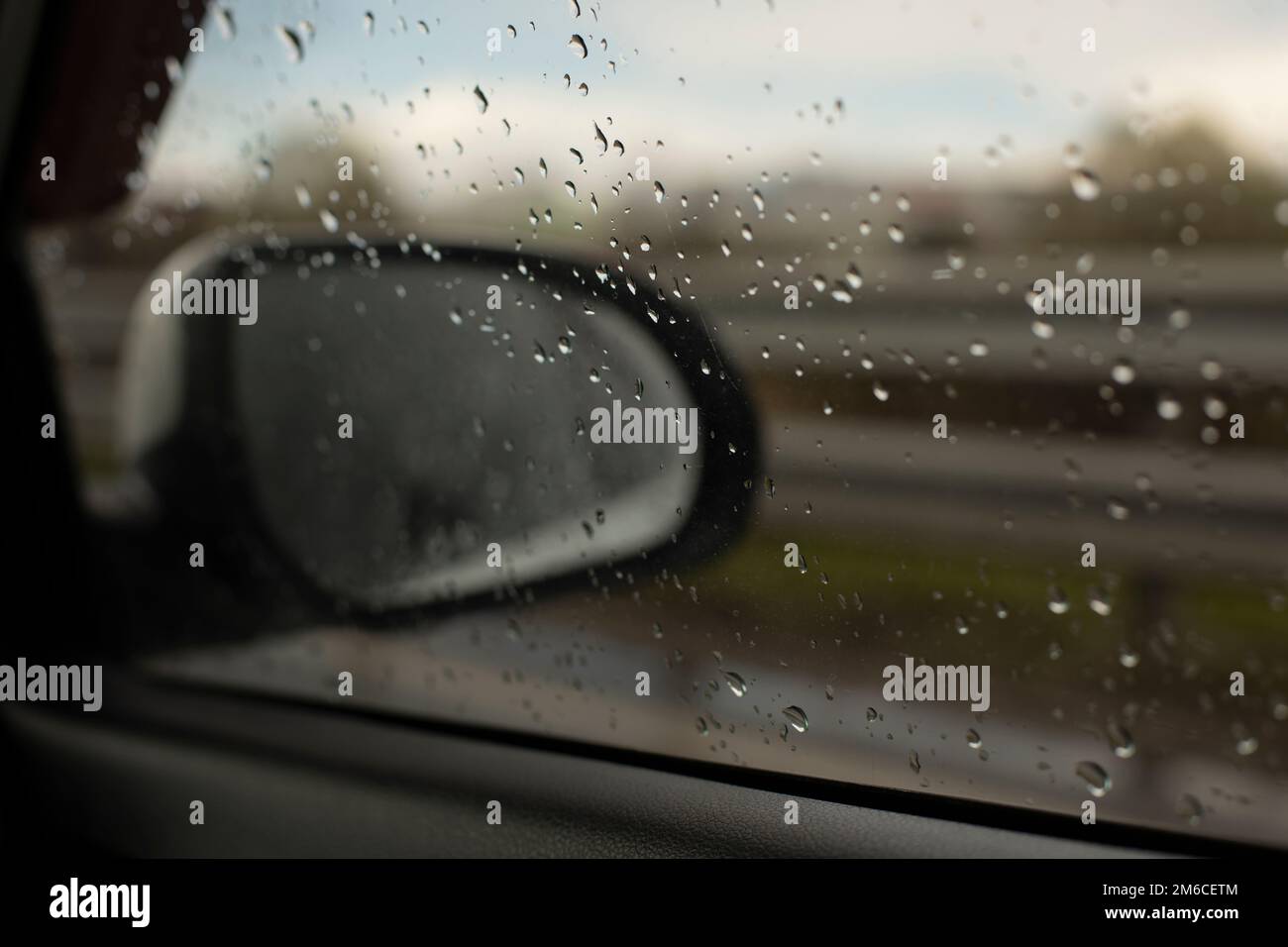 Specchietto retrovisore dell'auto dietro il cristallo bagnato. Foto Stock