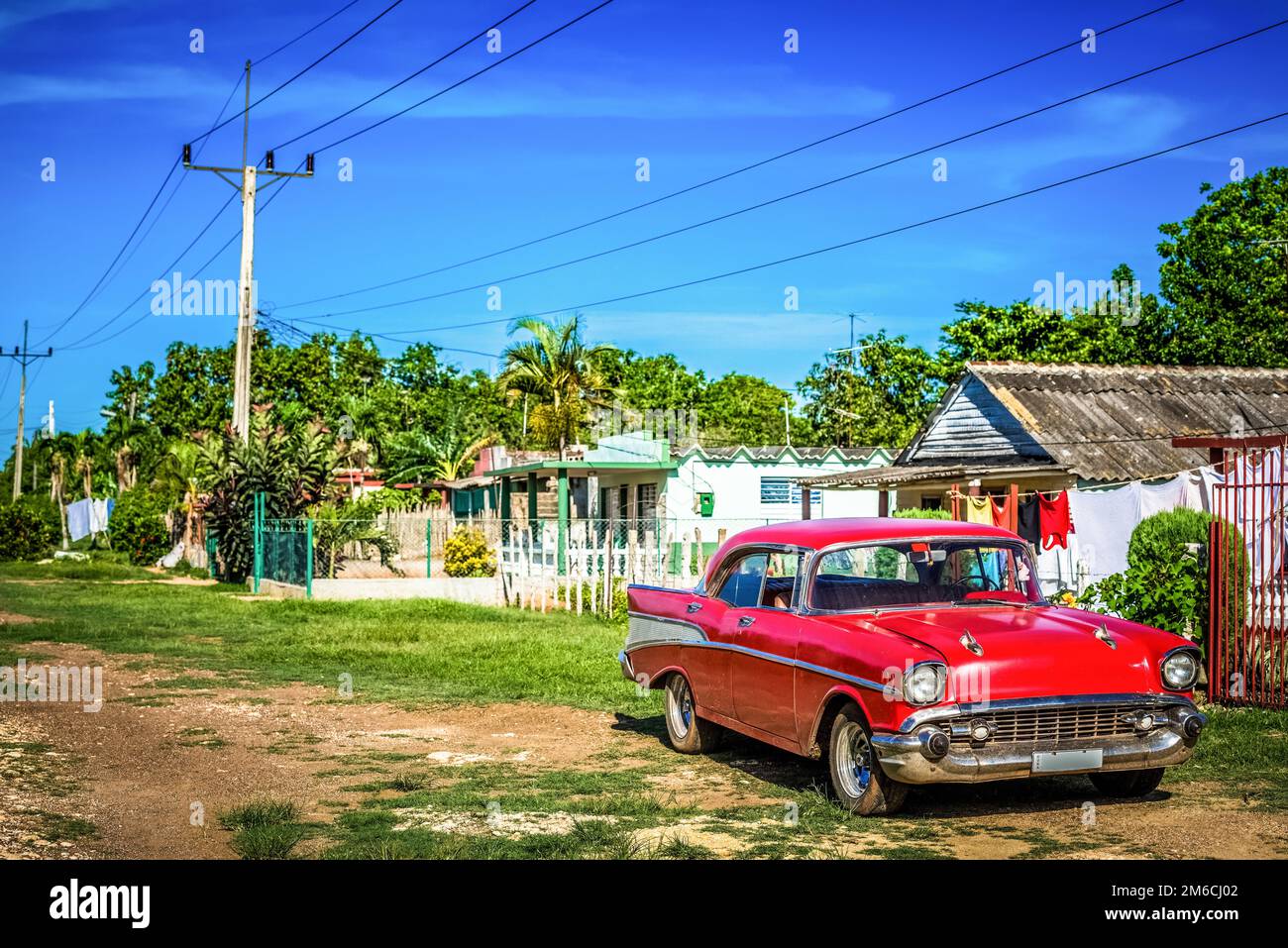 HDR - auto d'epoca rossa americana parcheggiata davanti ad una casa in campagna da Santa Clara Cuba - seri Foto Stock