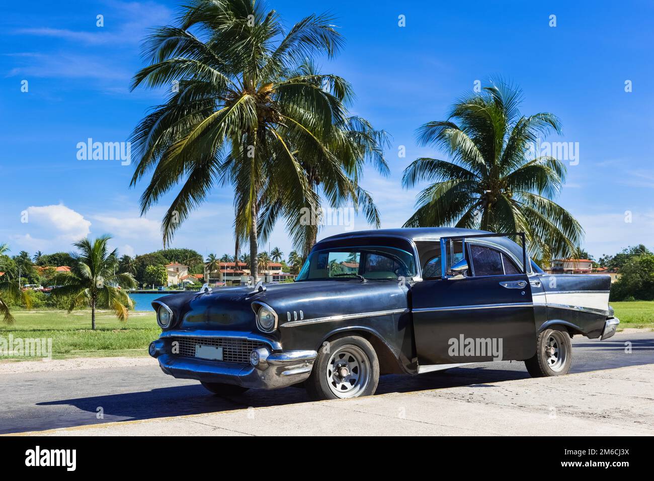 Nero americano parcheggiato sotto le palme a Varadero Cuba - Serie Cuba Reportage Foto Stock