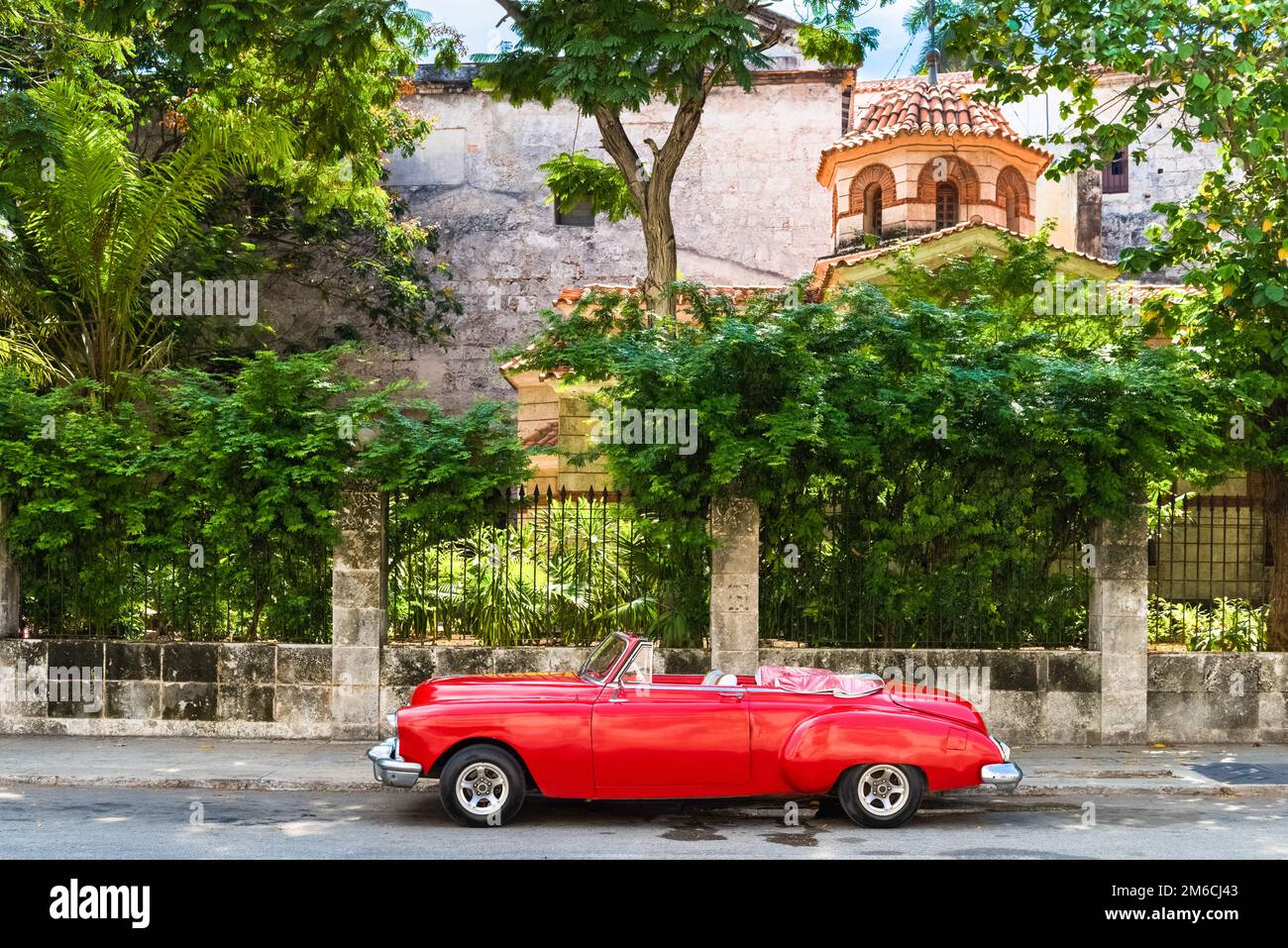 American rosso convertibile auto d'epoca parcheggiata sul Malecon di fronte a una fortezza el Morro a l'Avana Cuba Foto Stock