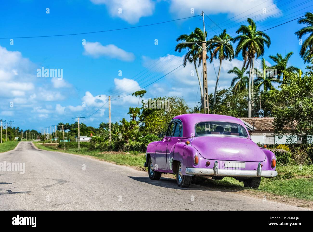HDR - parcheggiato american pink classica auto al lato strada sulla strada per Santa Clara Cuba Foto Stock