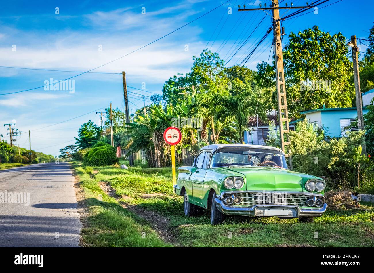 HDR - parcheggiato americano verde classico auto al lato strada sulla strada per Santa Clara Cuba Foto Stock