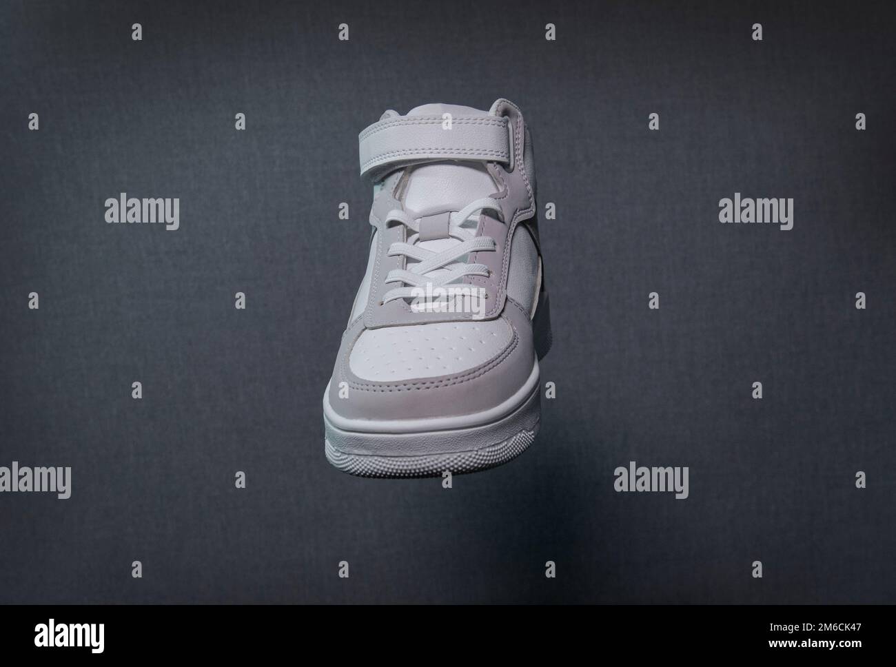 Sneaker bianca. parte frontale. Su sfondo grigio. Primo piano, texture Foto Stock