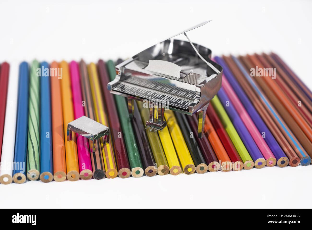 Piccolo pianoforte metallico con libro di note. Foto Stock