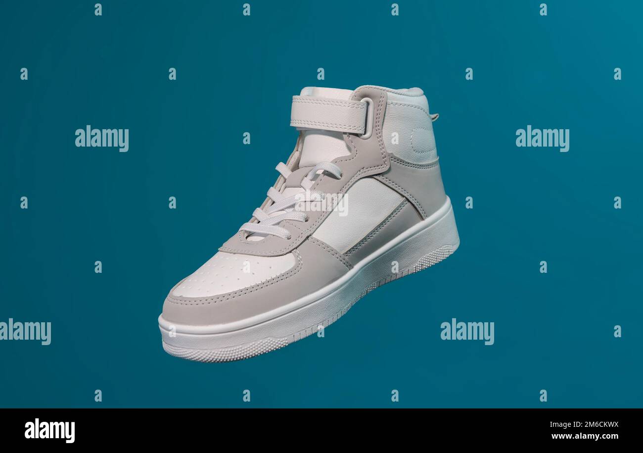 Una nuova sneaker bianca su sfondo blu Foto Stock