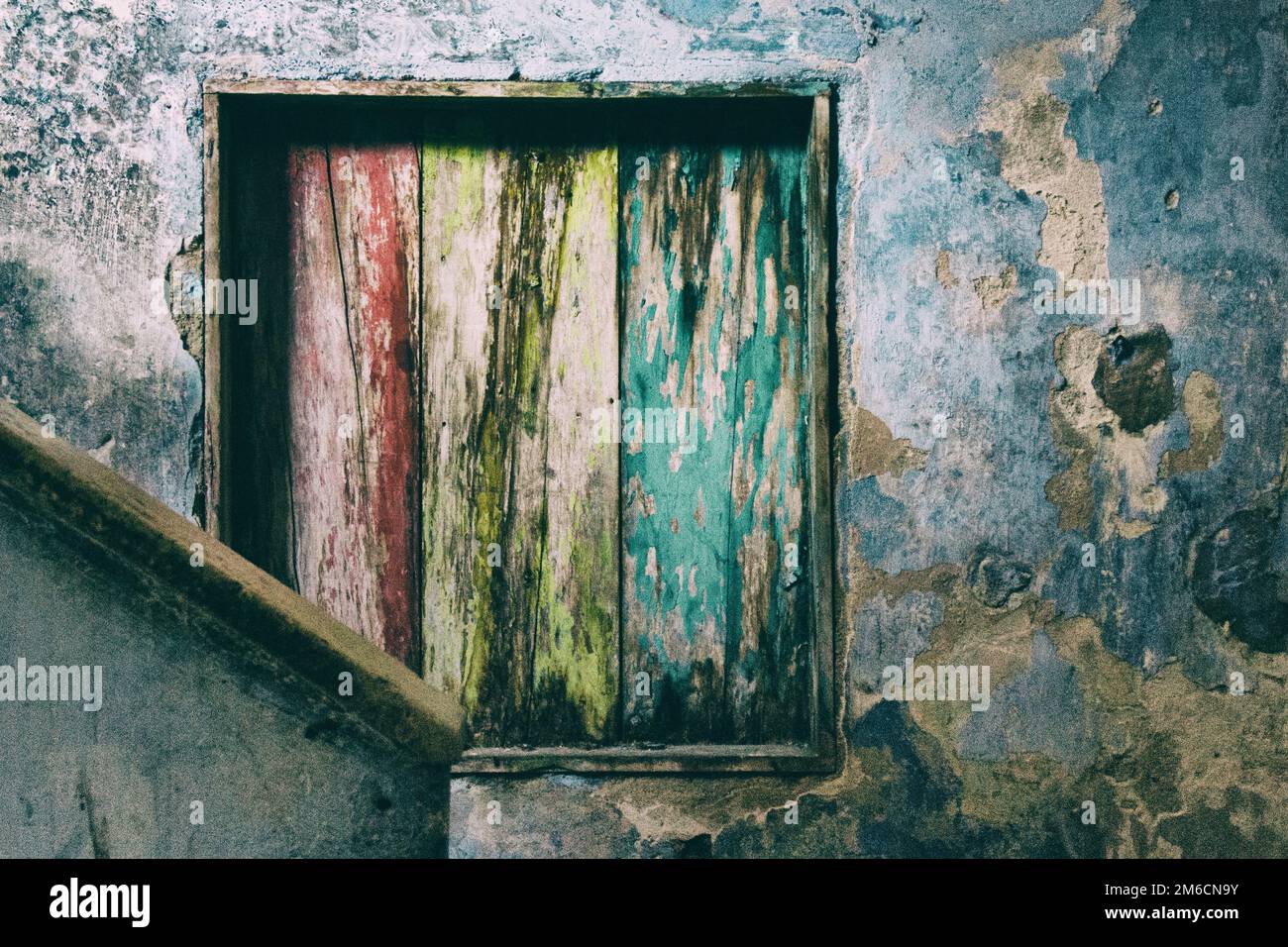 Bello sfondo di una colorata finestra di legno in un interno parete rovinata Foto Stock