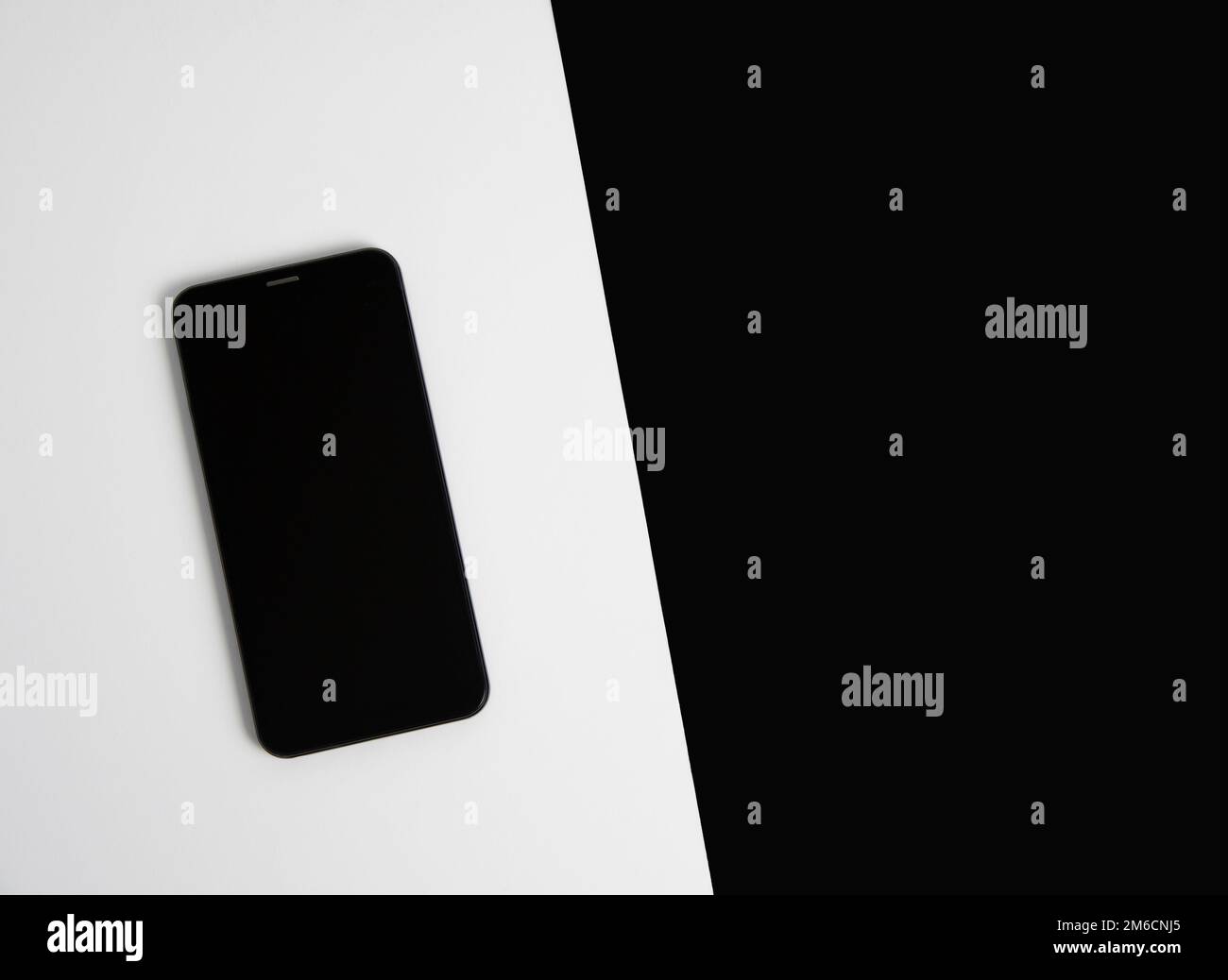 Smartphone su sfondo bianco e nero primo piano dall'alto. Scheda Foto Stock