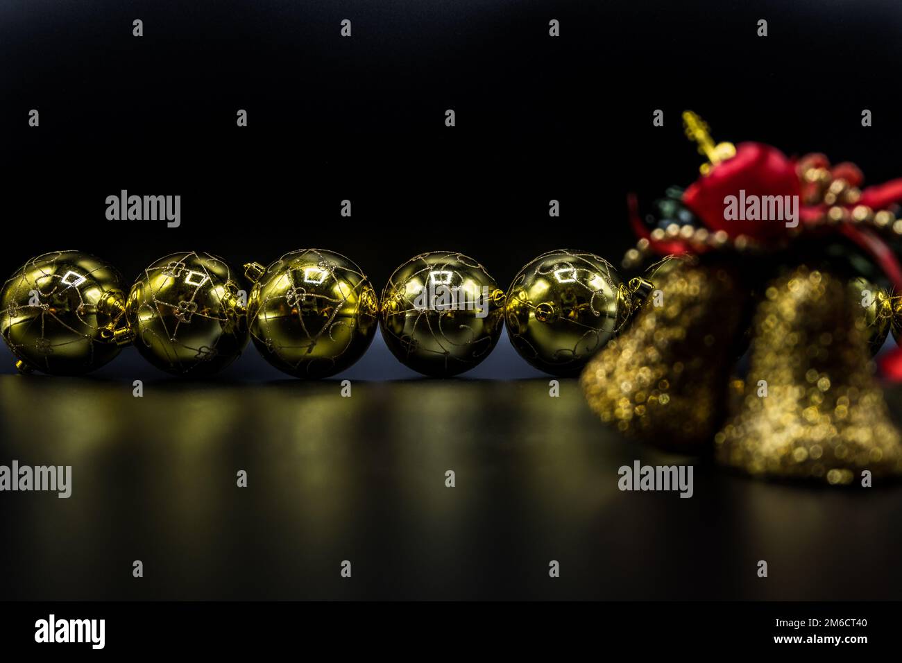 Golden Natale baubles e campane su sfondo nero. Foto Stock