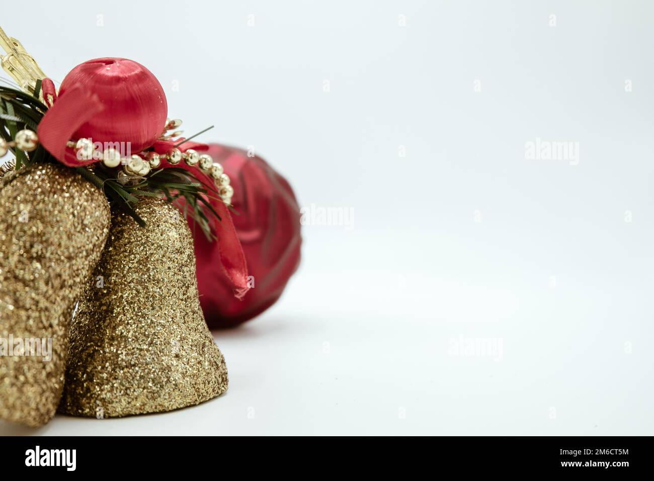 Oro albero di natale decorazioni campane con rosso babble. Foto Stock
