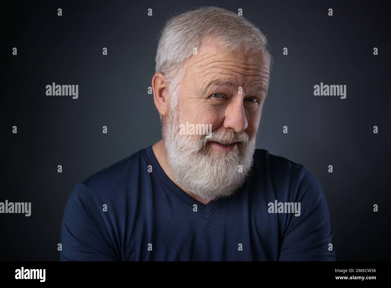 Uomo anziano con barba che guarda scettica Foto Stock