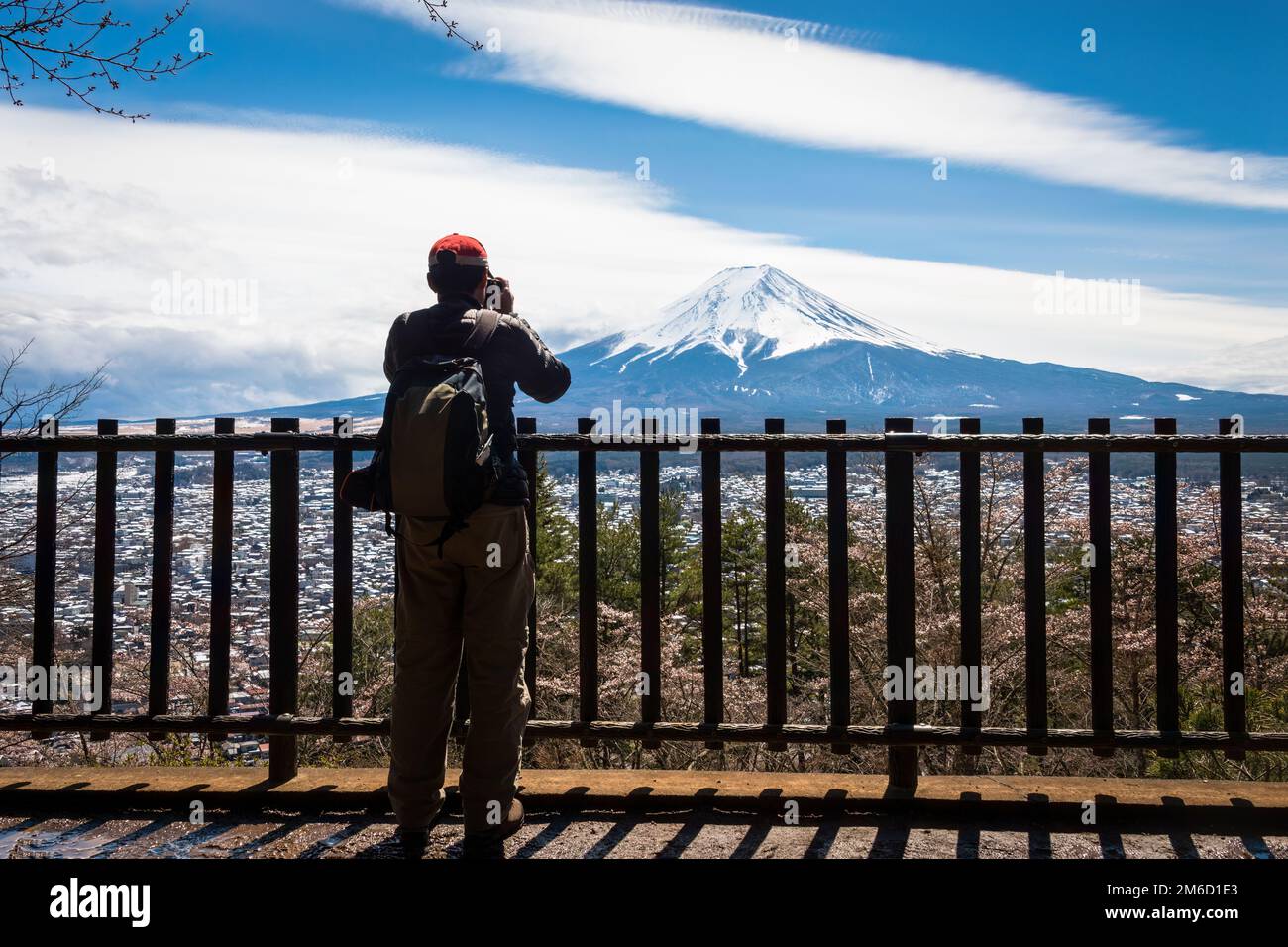 I turisti scattano foto del Monte Fuji innevato, incorniciato da alberi di ciliegio in fiore. Fuji Five Lakes, Giappone. Foto Stock