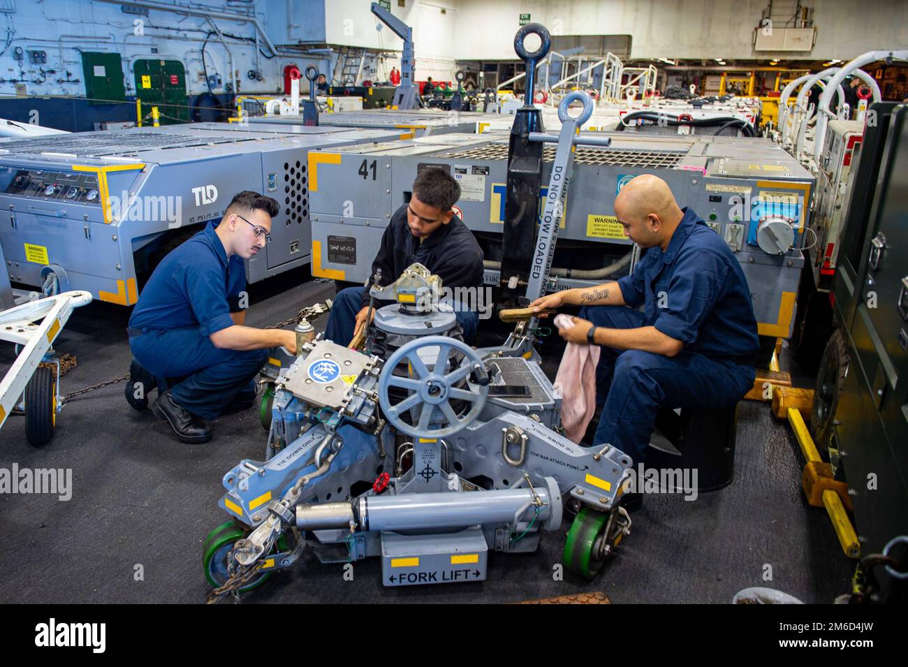 220423-N-TD381-1006 OCEANO PACIFICO (23 aprile 2022) – Aviation Support Equipmentman Airman David Ortega, a sinistra, un nativo di Los Angeles, California, Aviation Support Equipmentman 3rd Class James Cepriano, un nativo di San Francisco, California, E Aviation Support Equipmentman Airman Nesjohn Simon, nativo di San Diego, California, esegue un trattamento di corrosione su un sistema di sollevamento F-35C nella baia hangar della portaerei di classe Nimitz USS Carl Vinson (CVN 70) Aprile 23. Vinson sta attualmente conducendo operazioni marittime di routine nell'Oceano Pacifico. Foto Stock