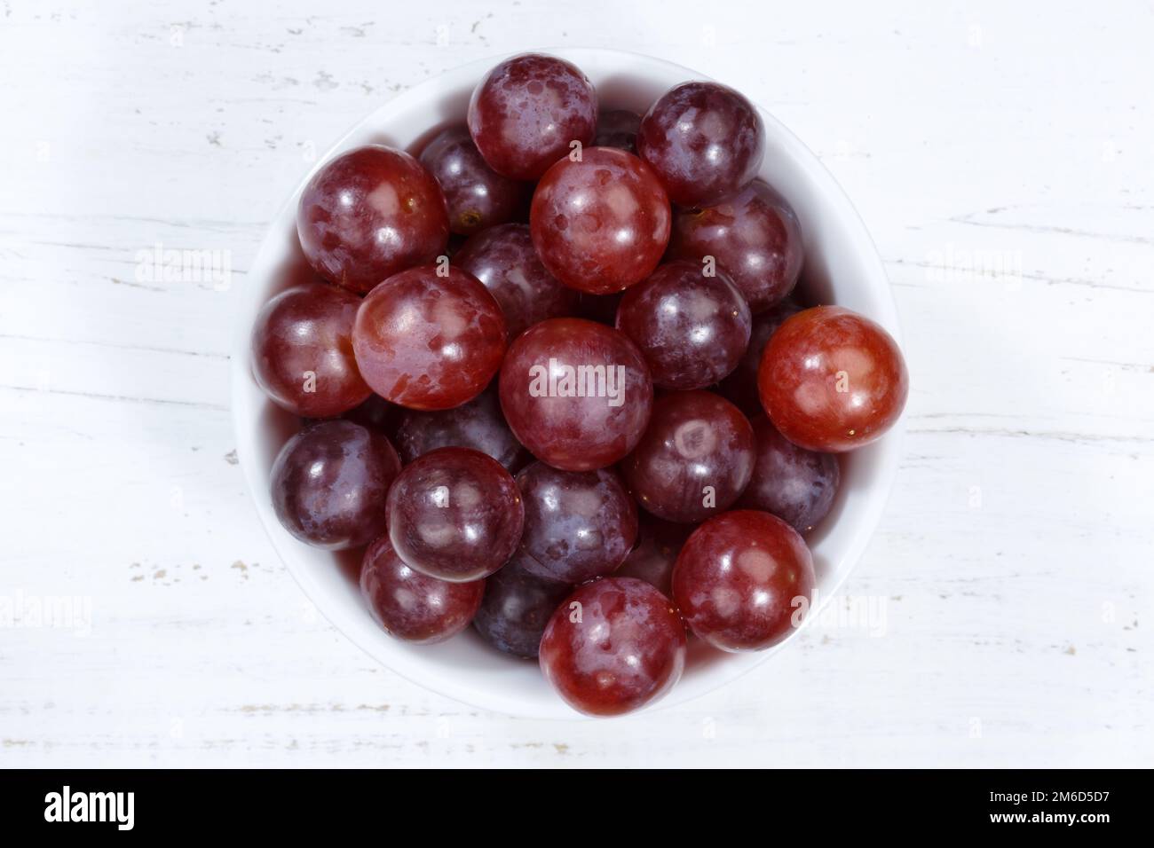 Uva frutta rossa frutta da sopra ciotola tavola di legno Foto Stock