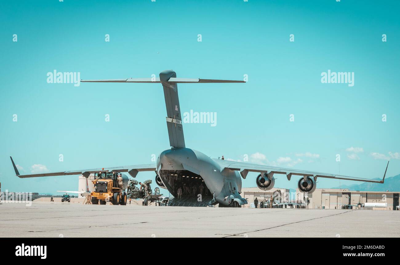 STATI UNITI Marines collabora con i membri degli Stati Uniti Air Force per caricare M777 obici trainati da 155 mm nella stiva di un C-17 Globemaster III alla base della riserva aerea di marzo, California, 23 aprile 2022. Gli obici fanno parte degli sforzi degli Stati Uniti, insieme ad alleati e partner, per identificare e fornire all’Ucraina capacità aggiuntive. Foto Stock