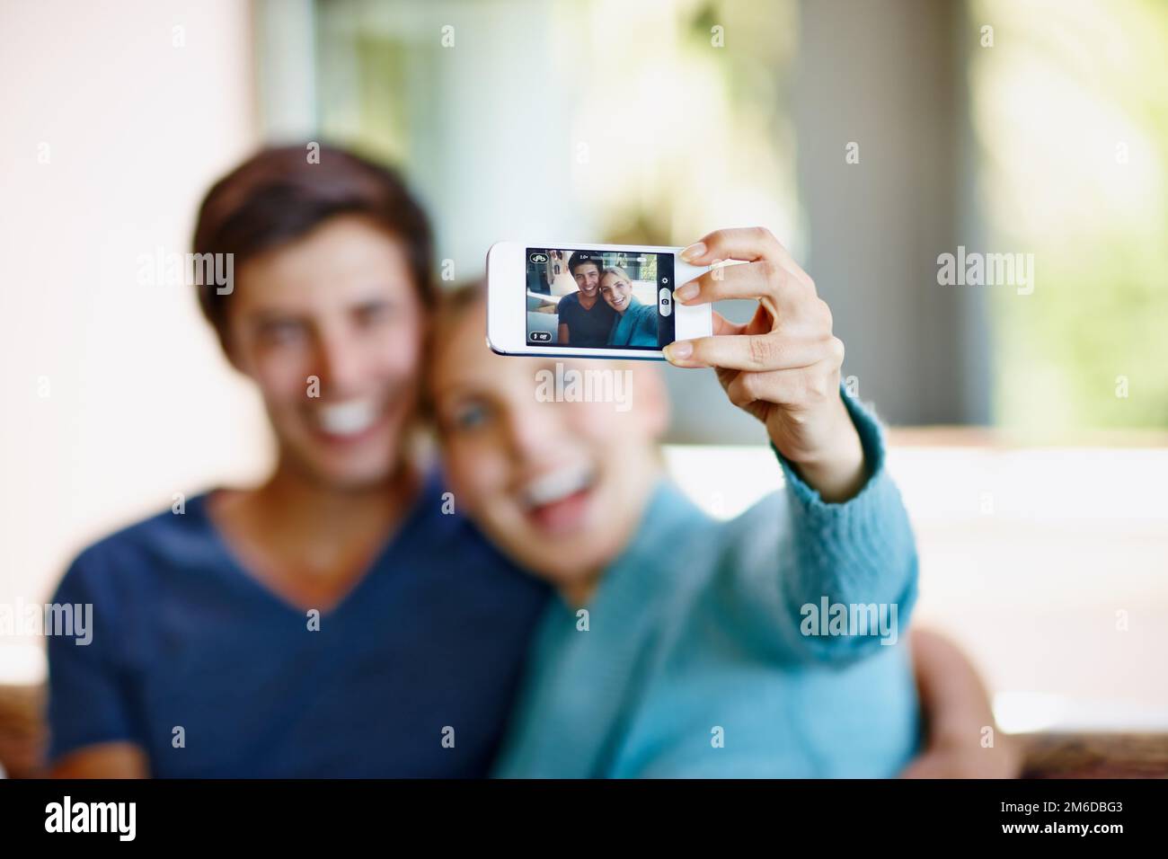 Aggancialo e invialo. una giovane coppia felice che prende un selfie insieme su un telefono cellulare. Foto Stock