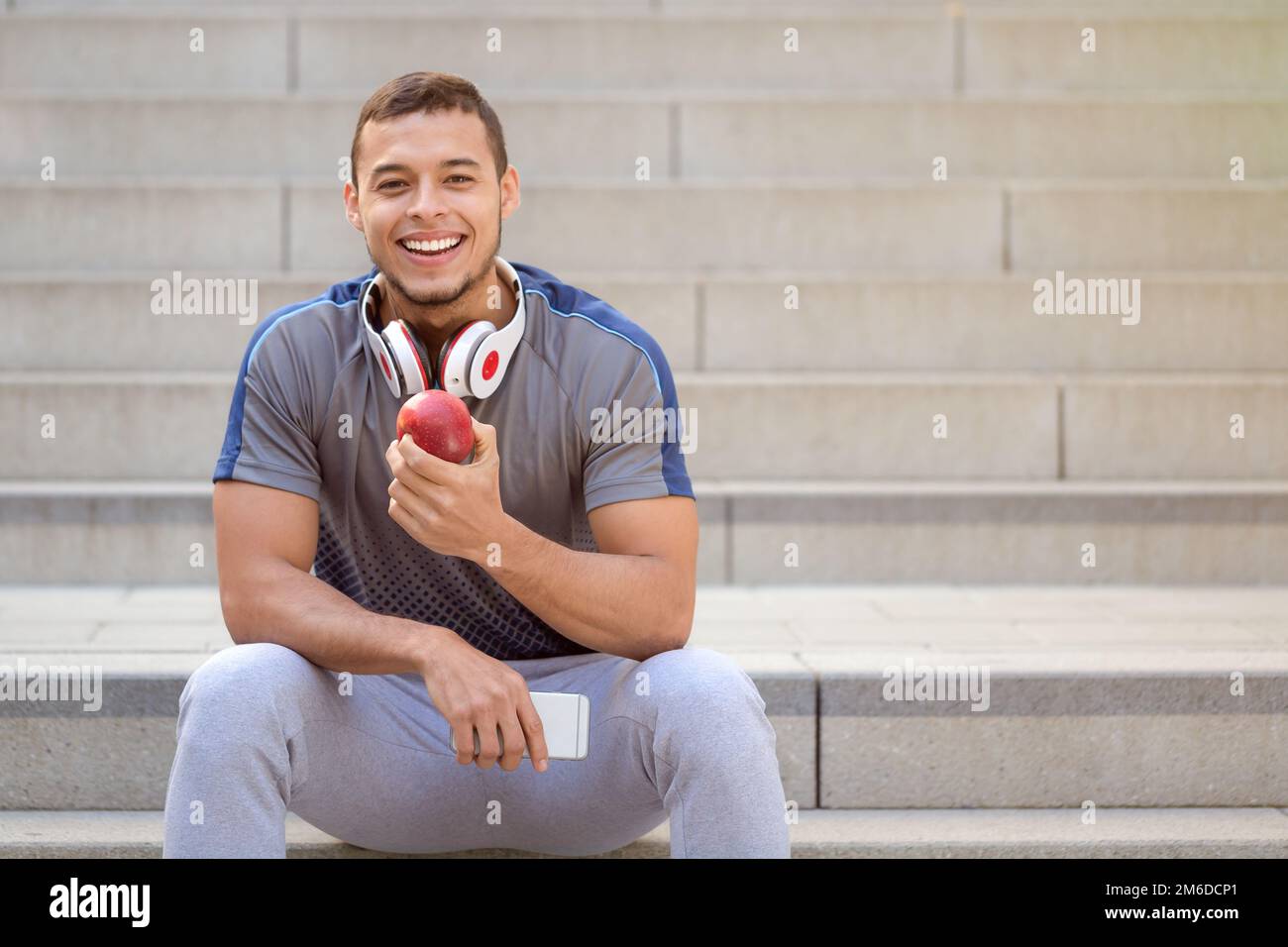 Sano mangiare mela frutta runner sorridente giovane uomo copyspace copia spazio sport allenamento fitness Foto Stock
