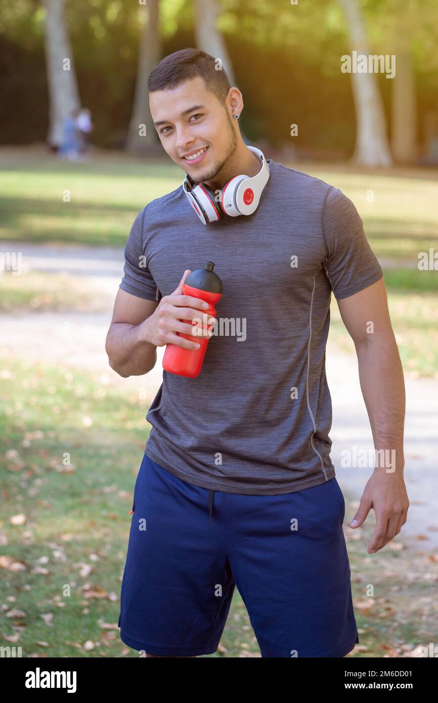 Ritratto formato runner sorridente giovane uomo latino corsa jogging sport allenamento fitness Foto Stock