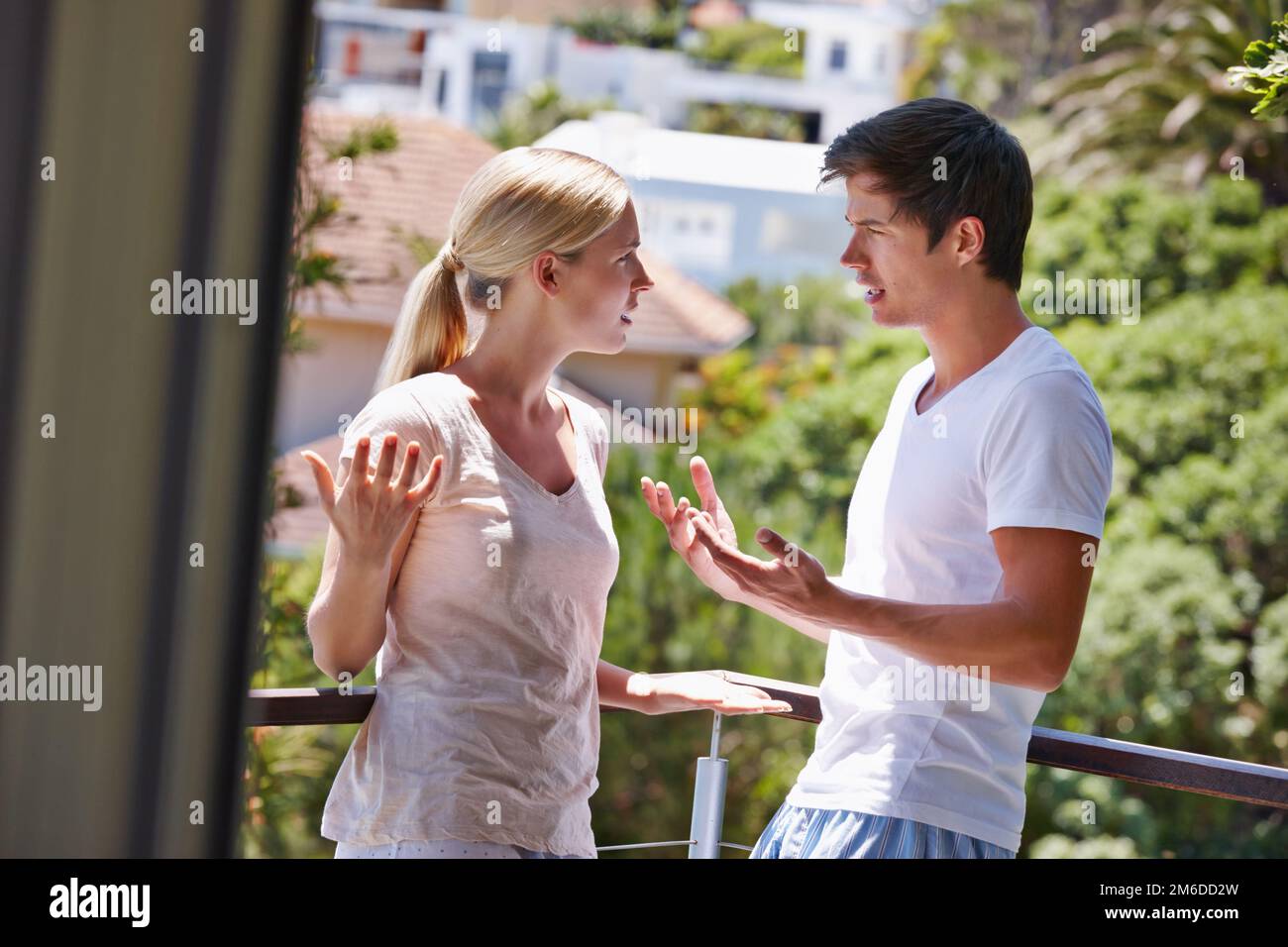 Discutiamo e combattiamo, ma stasera bene essere d'accordo. una giovane coppia che ha un argomento sul balcone della loro casa. Foto Stock