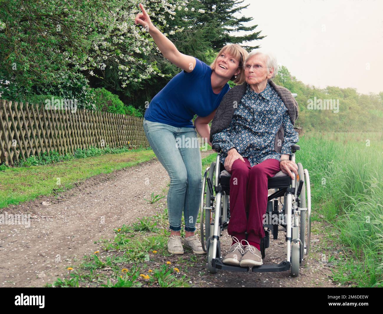 Donna anziana con giovane assistente nel parco Foto Stock