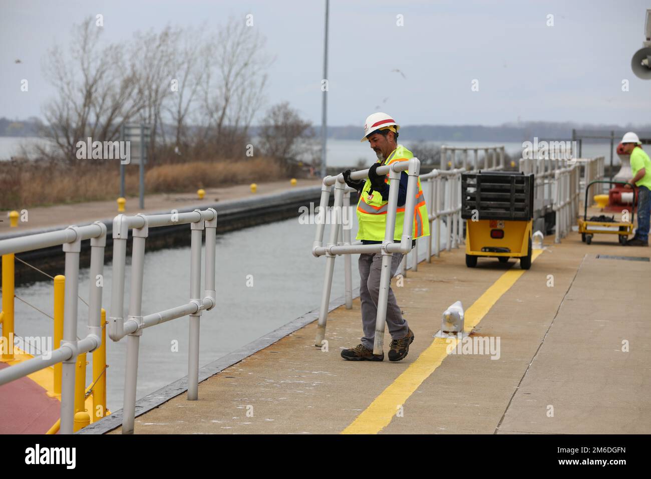 STATI UNITI Corpo dell'esercito degli ingegneri di Lock e Dam Operator Scott Newman mette la ringhiera di sicurezza lungo le pareti della serratura di Black Rock a Buffalo, New York, 25 aprile 2022. I membri del team, come Newman, garantiscono un funzionamento sicuro della serratura, che consente il passaggio di imbarcazioni commerciali e imbarcazioni da diporto dal porto di Buffalo al fiume Niagara. Foto Stock