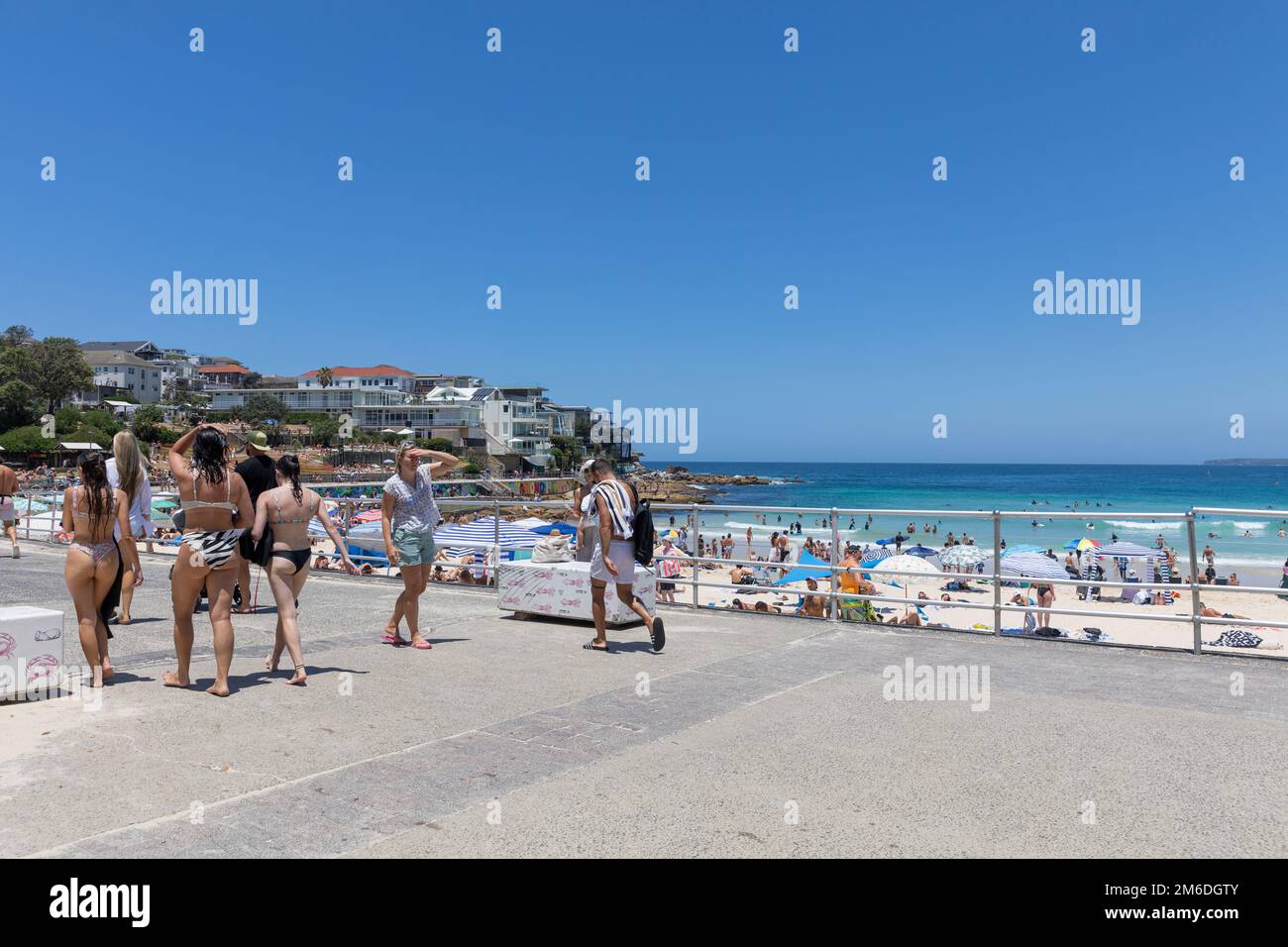 Affollata Bondi Beach estate 2023, persone a piedi lungo la passeggiata in bikini costumi da bagno, Bondi Beach, Sydney, NSW, Australia Foto Stock