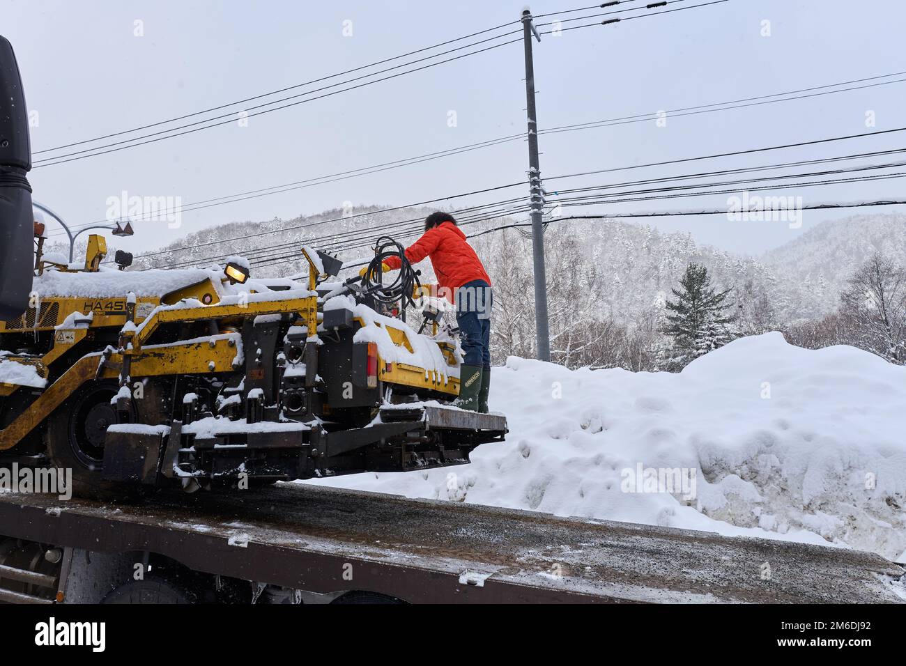 Hokkaido, Giappone - 19 dicembre 2022 : nella nevosa Hokkaido, il lavoratore sta ancora lavorando sodo Foto Stock