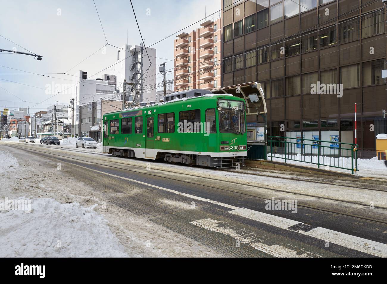 Hokkaido, Giappone - 20 dicembre 2022 : tram verde sulla strada innevata di Sapporo City Foto Stock