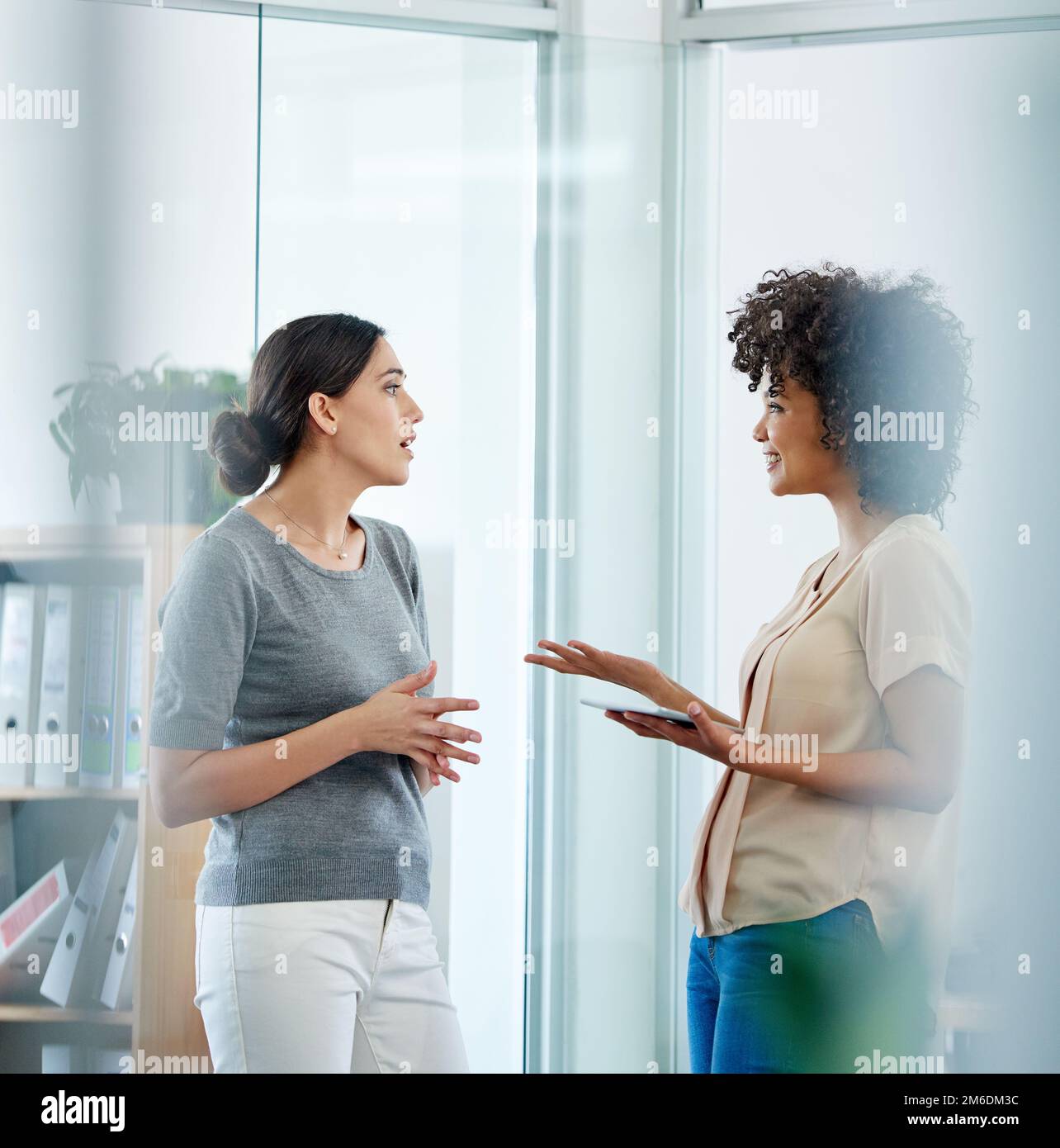 Linee di comunicazione aperte. due colleghi di sesso femminile che discutono nel loro ufficio. Foto Stock