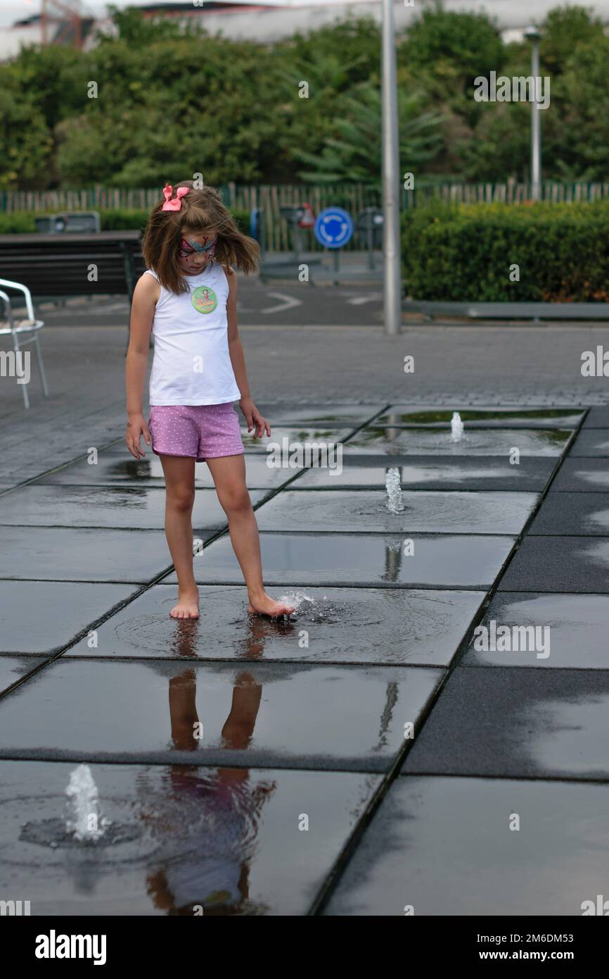 ragazza che gioca con una fontana Foto Stock