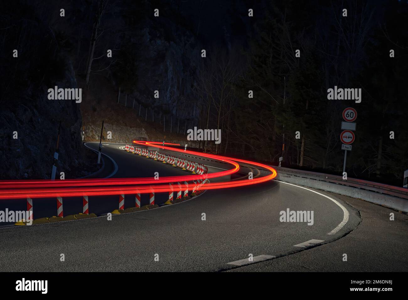 Sentieri leggeri di auto su strada curvy di notte Foto Stock