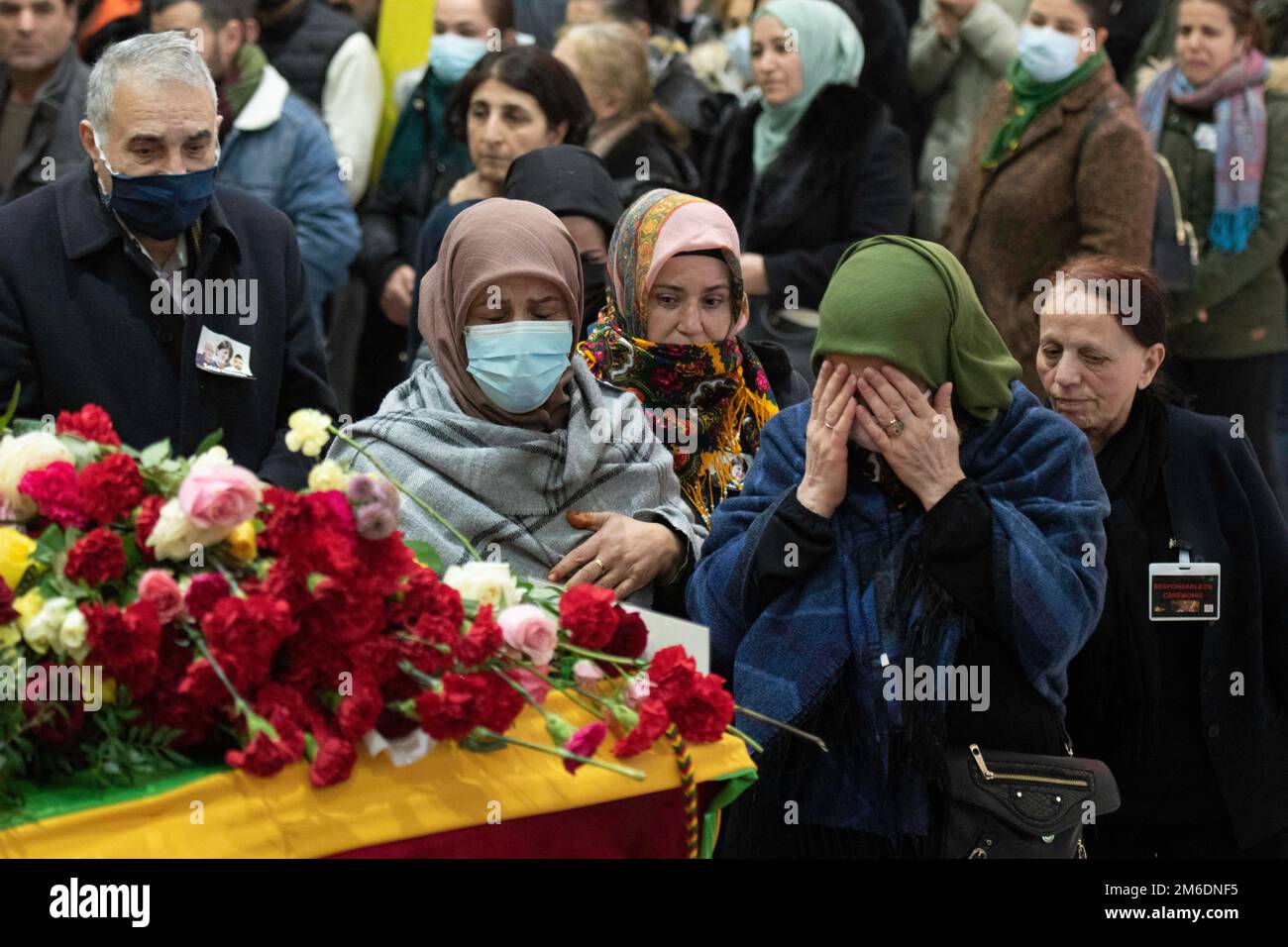 Villiers-le-Bel, Parigi, 3 gennaio 2023. I membri della comunità curda piangono alle bare, coperte di fiori, delle tre Enghien Street che sparano vittime durante un servizio funerario, nel sobborgo nord di Villiers-le-Bel, a Parigi, il 3 gennaio 2023. Tre persone sono state uccise e tre feriti in una sparatoria su Enghien Street nel centro di Parigi il 23 dicembre 2022, la polizia e i procuratori hanno detto, aggiungendo che lo sparatutto era stato arrestato. Un francese di 69 anni ha confessato un odio 'patologico' per gli stranieri, ha dichiarato il procuratore di Parigi Laure Beccuau il 25 dicembre 2022. Foto Foto Stock