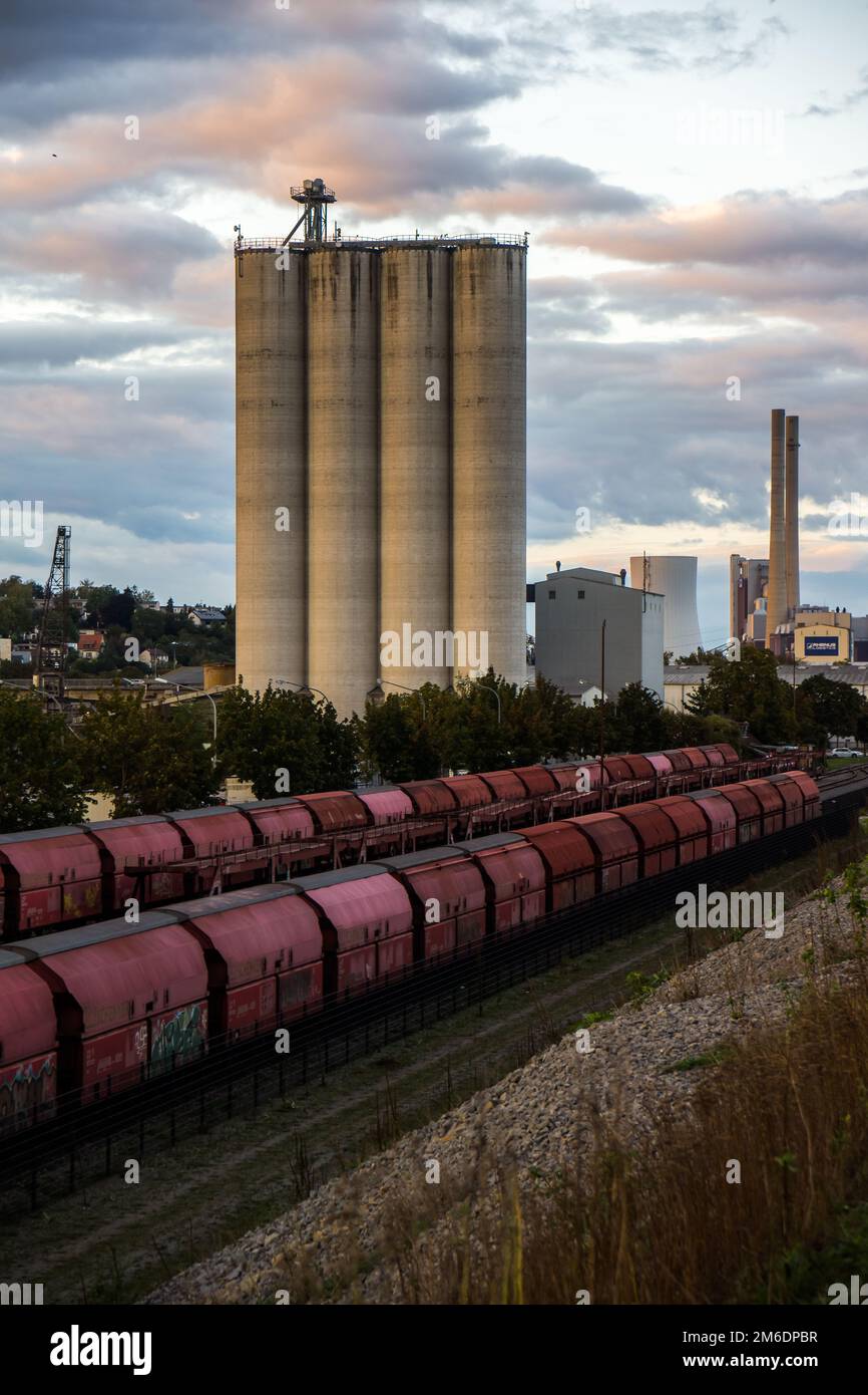 Contenitori ferroviari rossi all'incrocio ferroviario con silos Foto Stock