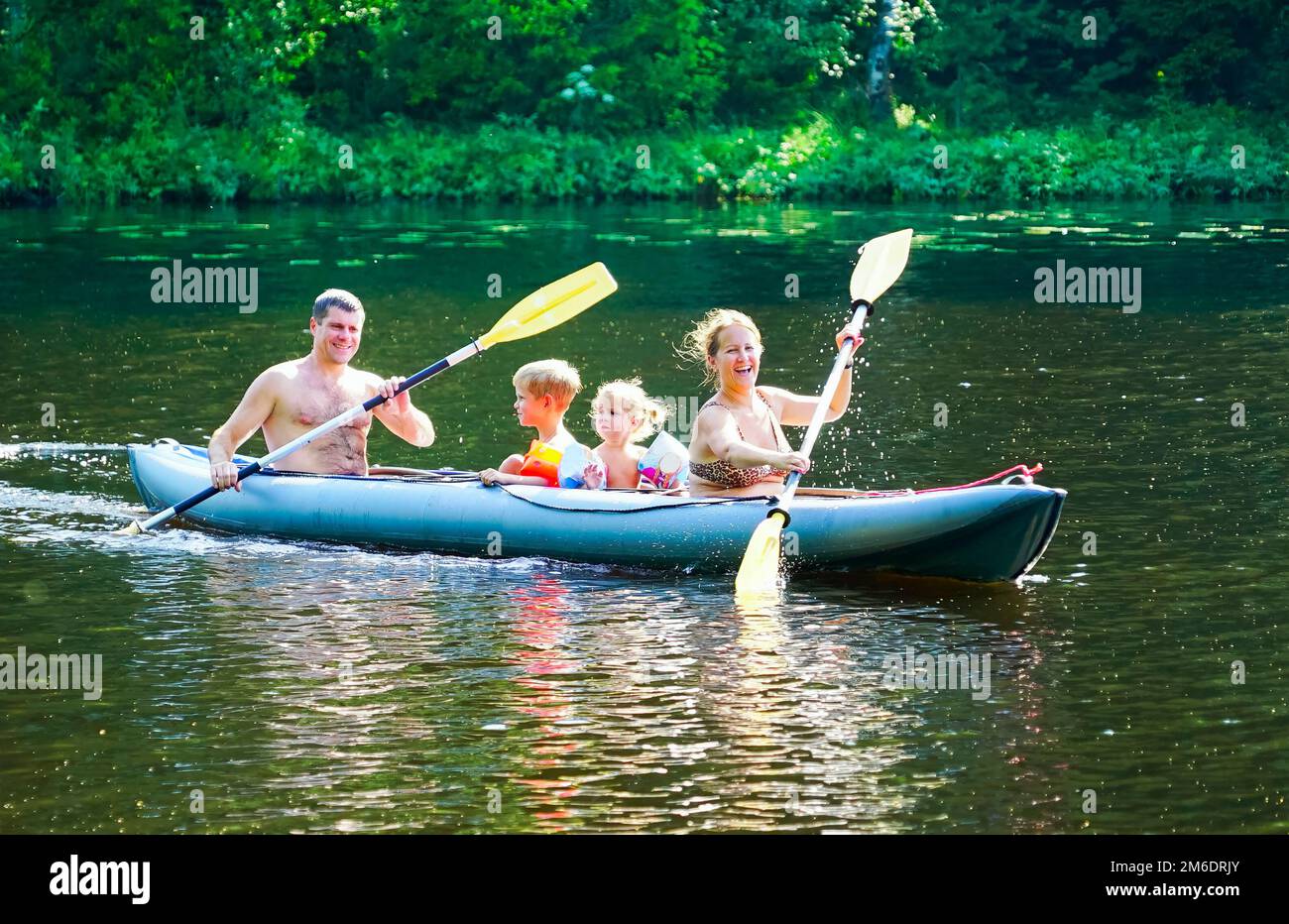 Una giovane famiglia con un figlio e una figlia sta facendo kayak sul lago . Foto Stock