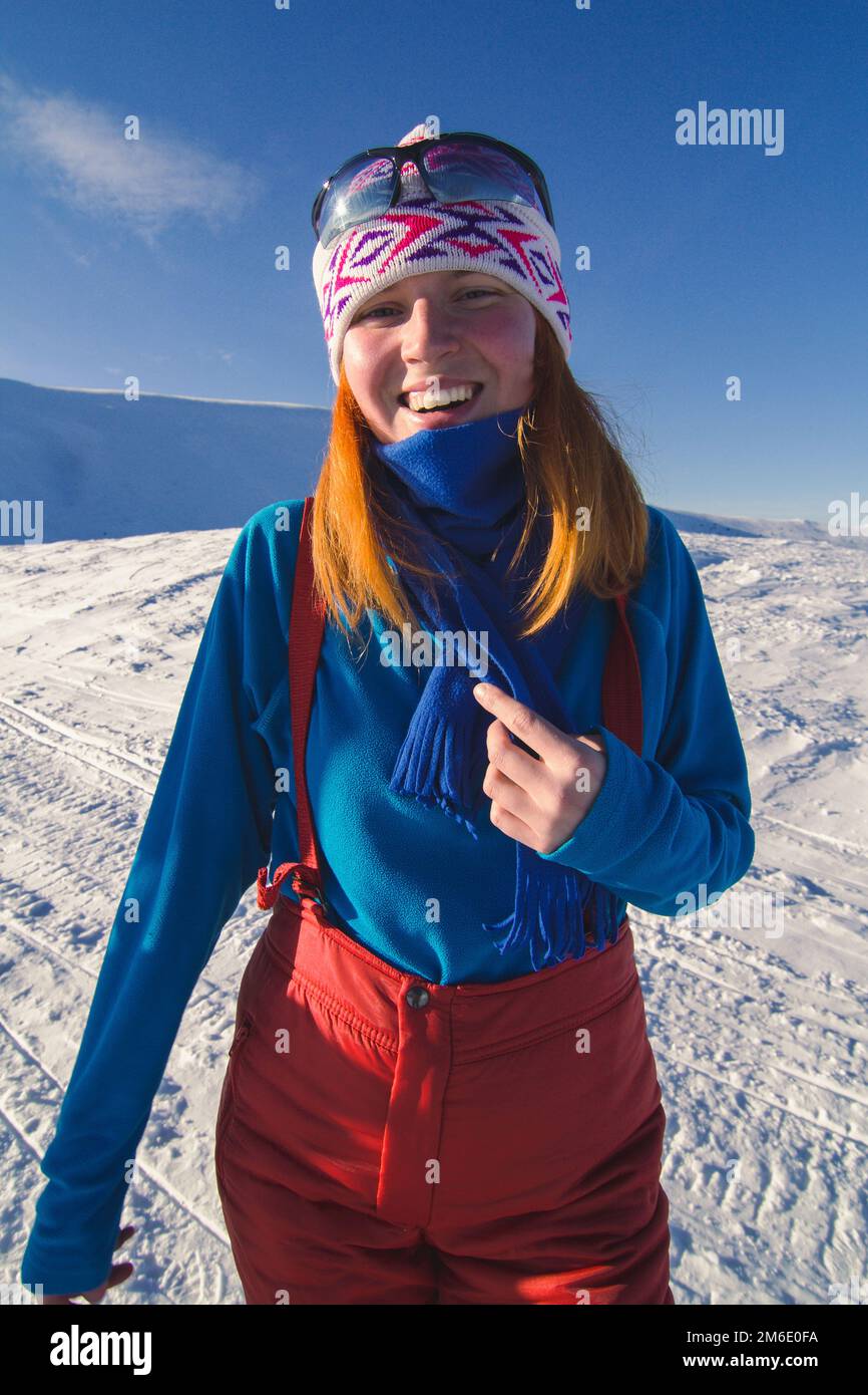 Primo piano giovane donna gioiosa sul ritratto di montagna innevata Foto Stock