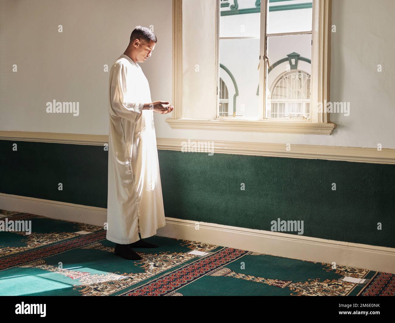 Musulmano, preghiera o uomo in una moschea che prega ad Allah per la consapevolezza spirituale, sostegno o benessere a Doha, Qatar. Religione, pace o persona islamica dentro Foto Stock