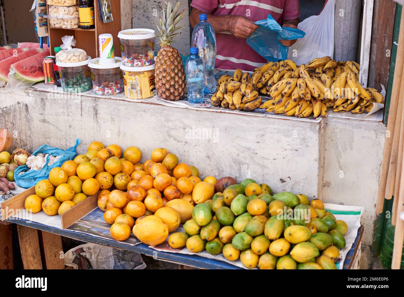 Frutta e snack in vendita. un venditore di strada che vende cibo al suo mercato stallo. Foto Stock