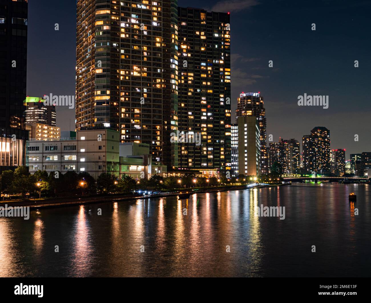 Alti edifici a Tokyo riflessi in un fiume Foto Stock