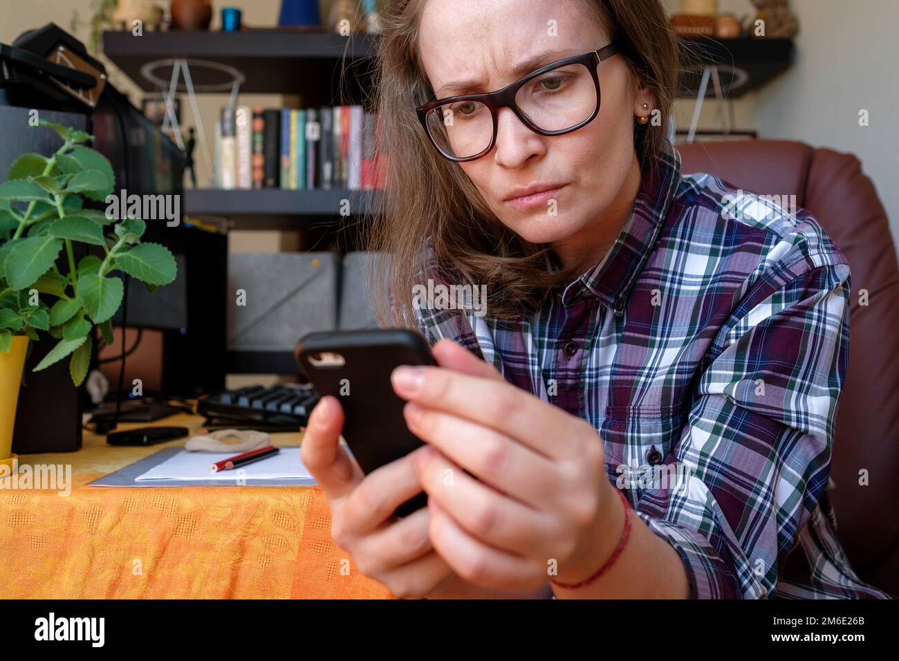 Una donna sta leggendo cattive informazioni da un gadget. Emozioni negative. Rimani a casa Foto Stock